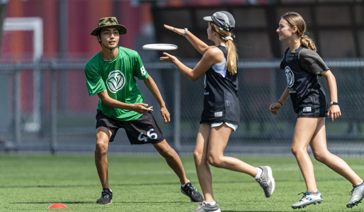 An instructor throwing a disc to a player